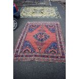 A Persian rug, having central medallion with urn design on a red ground with floral and geometric