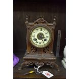 A late 19th century cast and pierced brass clock, 24.5cm high, with winding key.