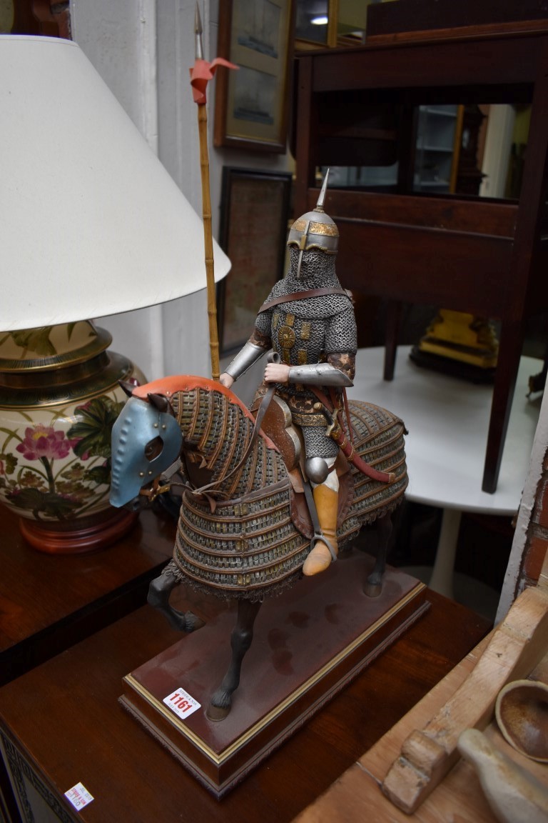 A polychrome painted composition figure of a medieval knight on horseback, on wooden base, total