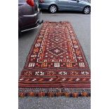 A Shiraz rug, having three central medallions with allover geometric design on a red ground, 278 x