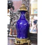 A pair of antique blue glazed porcelain and brass mounted rococo table lamps, the porcelain probably