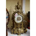 A cast brass mantel clock, 38cm high, with pendulum.