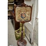 A Victorian rosewood pole screen, with Royal Coat of Arms needlework panel.