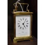 An old brass carriage timepiece, height including handle 14.5cm, with winding key.