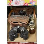 Two cased pairs of binoculars; together with another pair of field glasses.