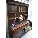 An early 19th century oak dog kennel dresser and rack, 150.5cm wide.