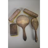 A silver four piece backed engine turned dressing set; together with another similar brush. (5)