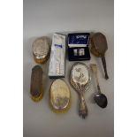 A silver hand mirror; together with four silver backed brushes etc. (7)