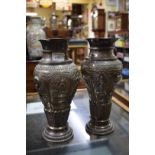 Two highly decorated Siamese white metal baluster vases showing scenes of temples, wild animals