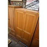 A contemporary pale oak double wardrobe, with apron drawer, 100.5cm wide.