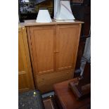 A contemporary pale oak double wardrobe, with three apron drawers, 110cm wide.