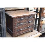 A carved oak miniature three drawer chest, 33cm wide.