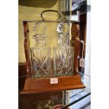 A mahogany and electroplated two bottle tantalus, with Brierley cut glass decanters and stoppers,