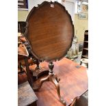 An antique mahogany tilt top tripod table, with piecrust top, 57cm diameter.