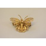 An unmarked yellow metal filigree butterfly brooch, stamped c18, 3cm.