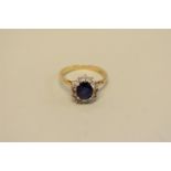 A sapphire and diamond cluster ring, stamped 18ct, 3.6g total weight.