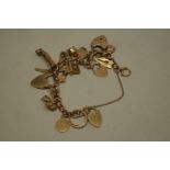 A gold charm bracelet, stamped 375, having seventeen charms, some stamped 9ct, 38.2g gross weight.