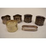 A pair of Edwardian silver embossed napkin rings, by J & R Griffin, Chester 1902; together with four