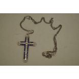 A diamond and sapphire encrusted unmarked cross pendant, having fine white gold chain stamped 750,