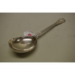 An Arts & Crafts planished silver serving spoon, by Omar Ramsden, London 1928, Tudor Rose pattern,