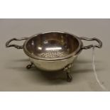 A silver tea strainer and stand, by Barker Ellis Silver Co, Sheffield 1966, 11.5cm wide, 85g.