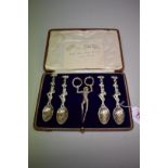 A cased set of four silver 'Pierrot' teaspoons and sugar nips, by C Hanbury-Tracey, Baron Sudeley,