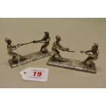 An unusual pair of Victorian silver plated 'tug of war' knife rests, depicting military and naval
