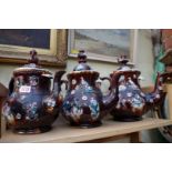 Three Victorian Bargeware teapots and covers, largest 32cm high, (each s.d.).