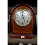 An Edwardian mahogany and inlaid mantel clock, striking on a gong, 31cm high, with pendulum.