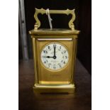 An old brass carriage timepiece, with ivorine dial, height including handle 14cm.