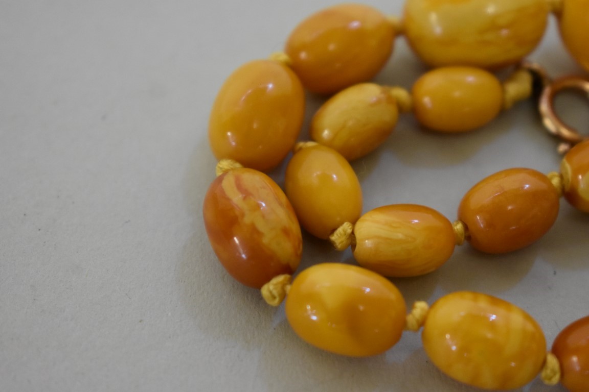 A 'butterscotch' amber bead necklace, of twenty nine oval graduated beads, with unmarked yellow - Image 3 of 3