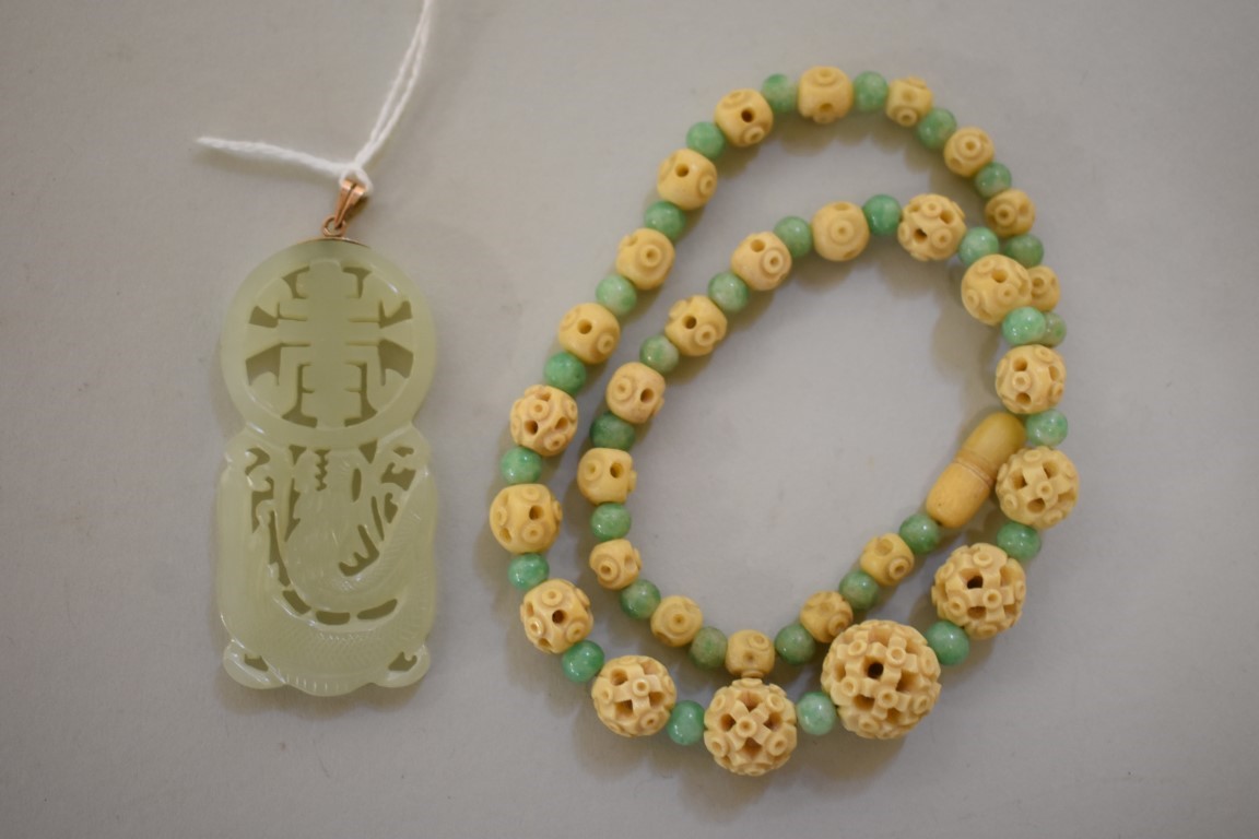 A Chinese carved and pierced celadon jade pendant, decorated with a dragon, 5.8cm high, the yellow
