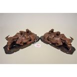 A pair of Chinese carved wood buffalo figure groups, late 19th century, each recumbent animal with