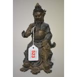 A Chinese bronze seated figure, with remains of painted and gilt decoration, 21.5cm high.