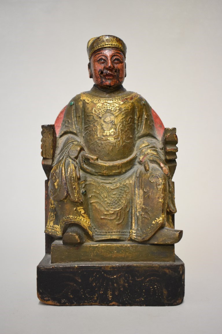 A Sino-Tibetan carved and painted wood seated figure, 30cm high.