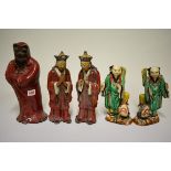 Three Chinese Shiwan flambe figures, comprising: a Daoist, 30cm high; and a pair of attendants, 27cm
