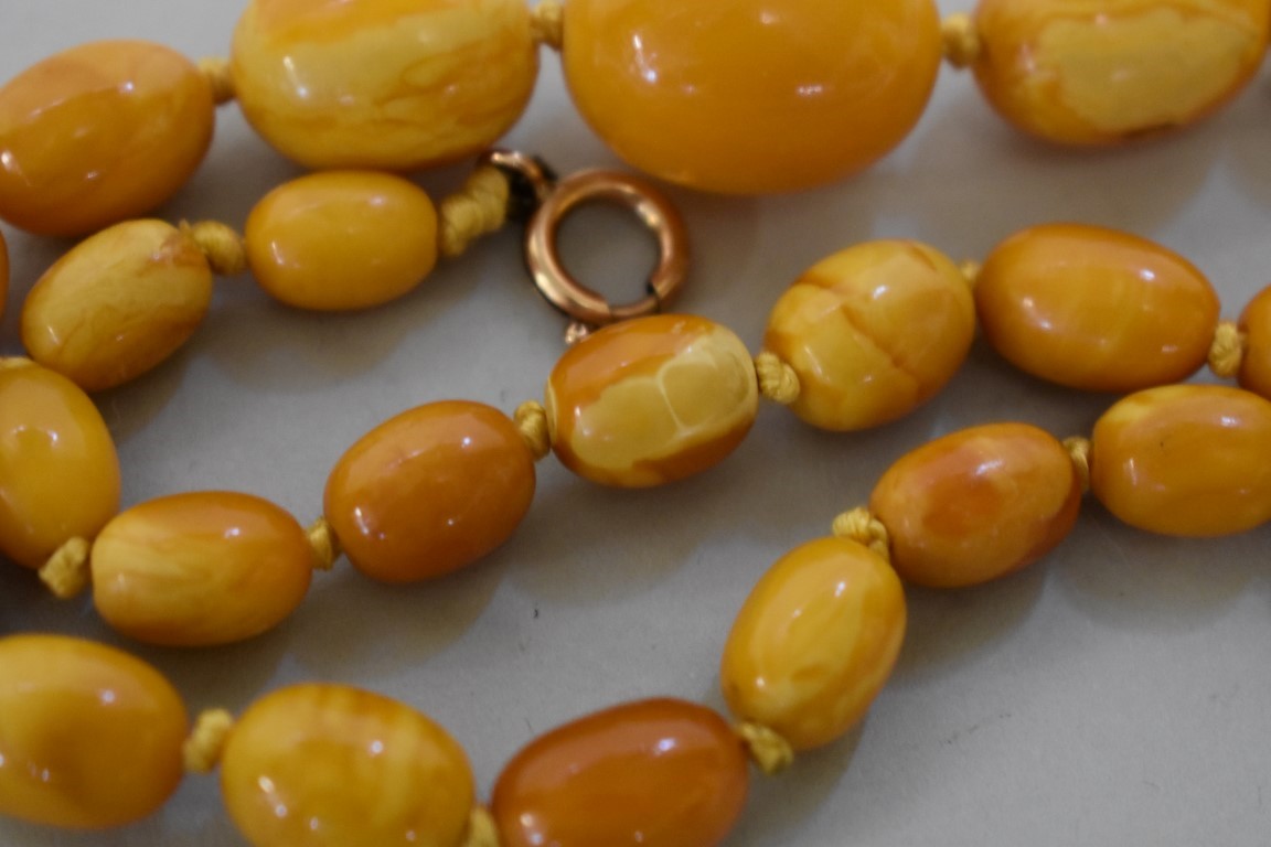 A 'butterscotch' amber bead necklace, of twenty nine oval graduated beads, with unmarked yellow - Image 2 of 3