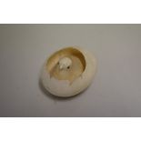 A Japanese novelty ivory chick in egg carving, 5cm wide.