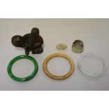 A small group of Chinese jade, comprising: three bangles, on with wrythen decoration, a carved