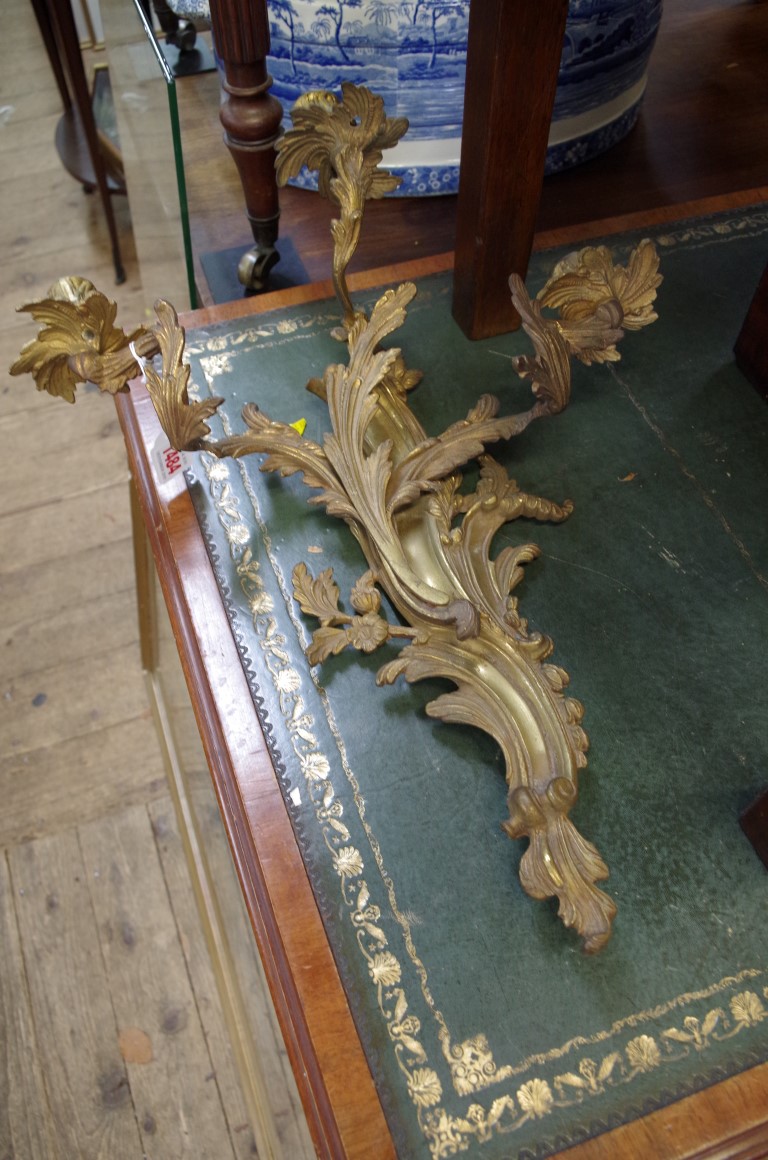 A pair of rococo style cast brass three branch wall lights, 51cm high.