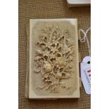 A 19th century carved ivory card case and aide memoire, finely carved in high relief with a floral