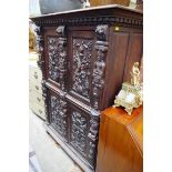 An antique Continental carved oak press cupboard, 117cm wide.