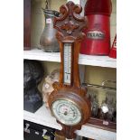 An Edwardian carved walnut aneroid banjo barometer, by Dollond & Aitchison.