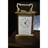 A brass carriage timepiece, height including handle 15cm, with winding key.