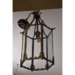 Two brass and glass hanging lanterns, largest 36cm high.