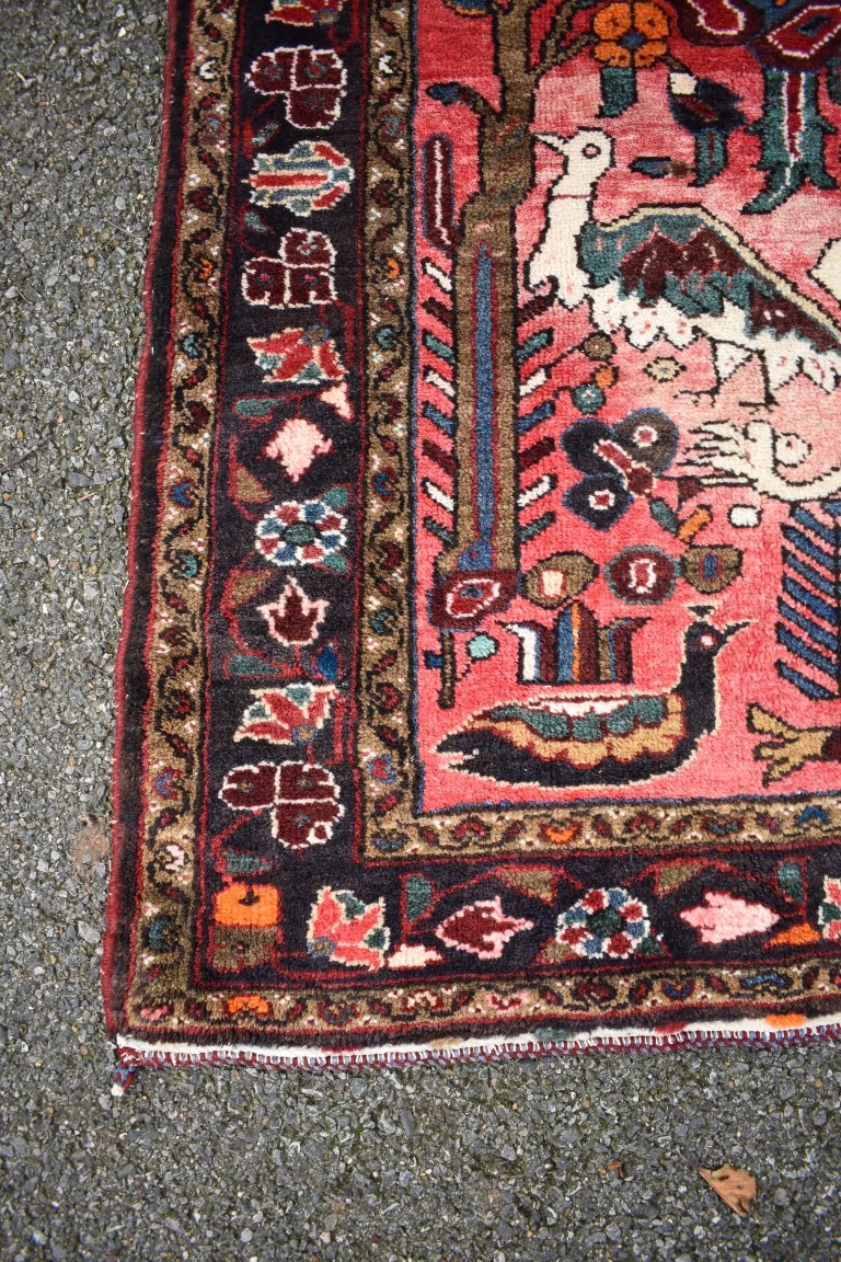 An Eastern rug, having animal motifs on a red field, with floral borders, 320 x 127cm. - Image 2 of 3