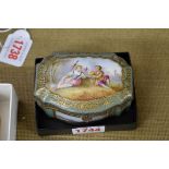 A 19th century Continental porcelain casket, painted to the hinged cover with lovers in a landscape,