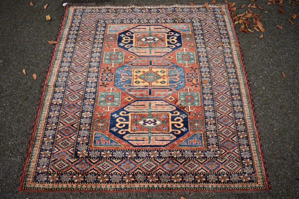 A Persian rug, having three central medallions with floral and geometric borders, 154 x 144cm.