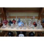 A collection of clear and coloured glass scent bottles and stoppers.