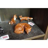 Three Beswick foxes, largest 10cm wide.